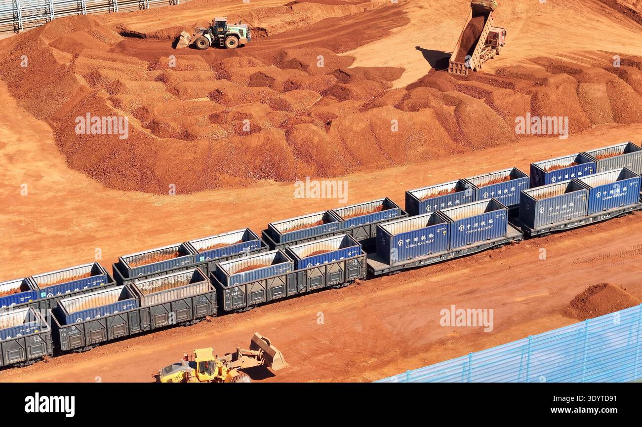 Loaders load imported bauxite ore onto a cargo train, ready to be ...