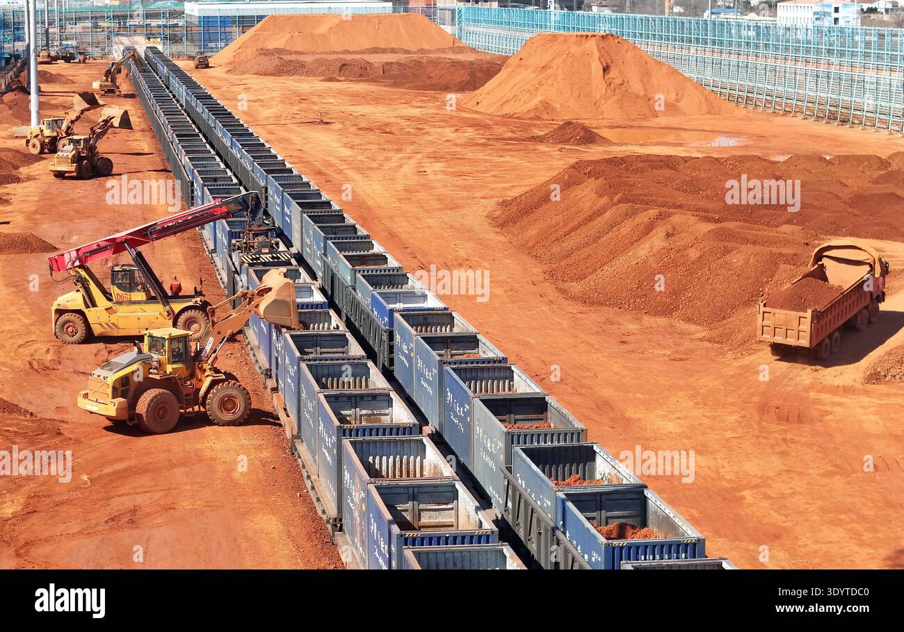 Loaders load imported bauxite ore onto a cargo train, ready to be ...