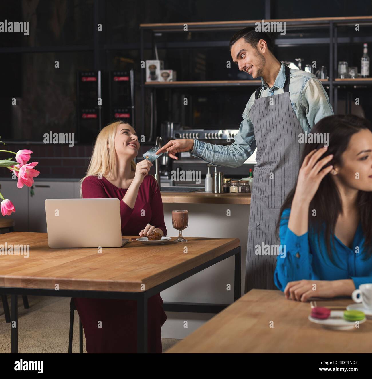 Smiling waiter taking payment from client Stock Photo
