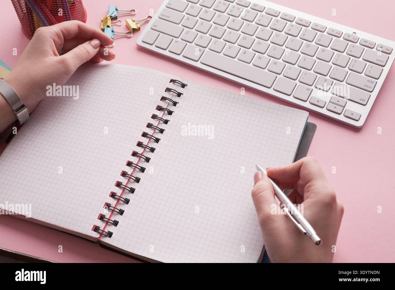 Woman's hands holding pen and spiral notepad Stock Photo