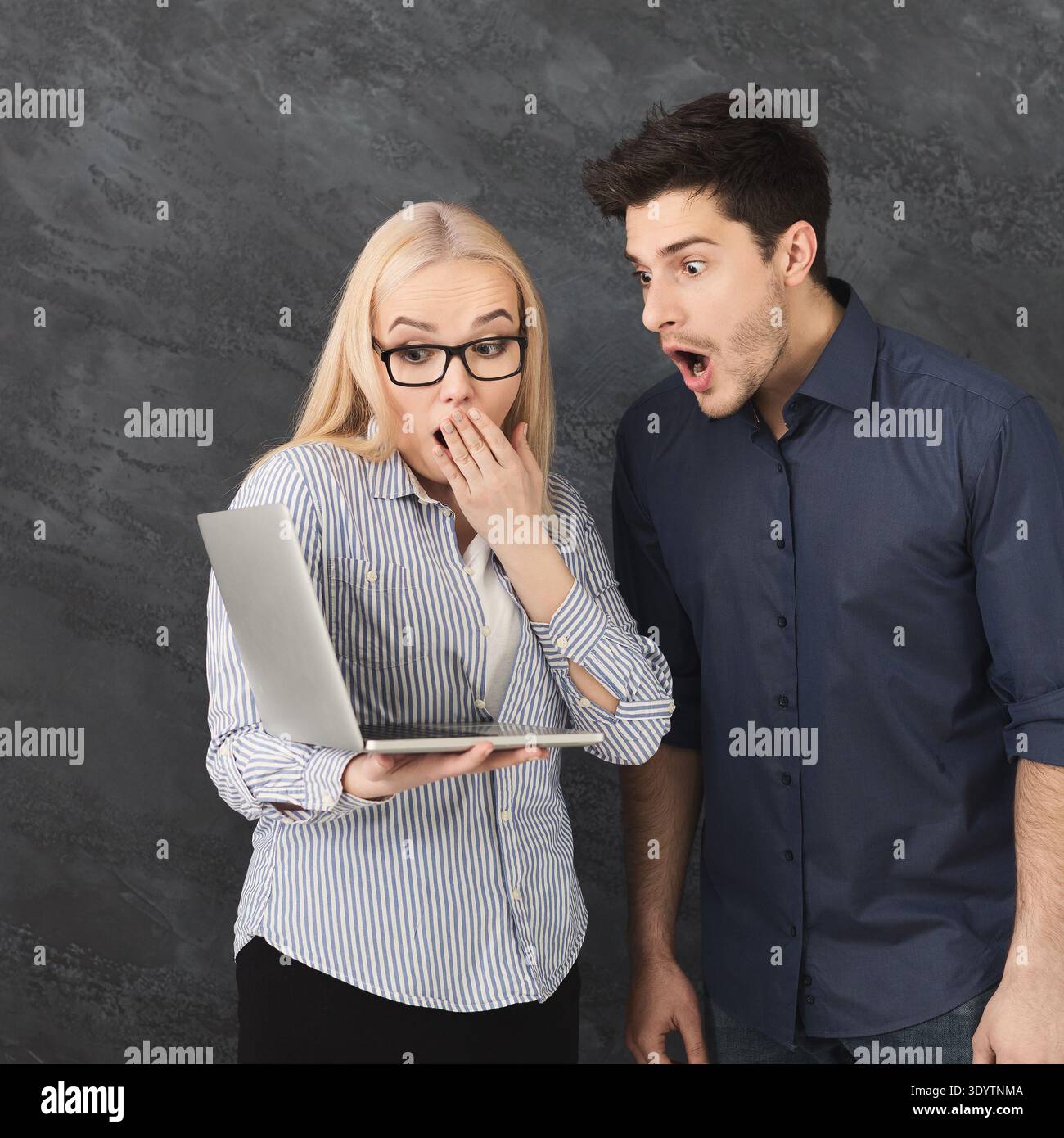 Shocked couple using laptop at studio Stock Photo
