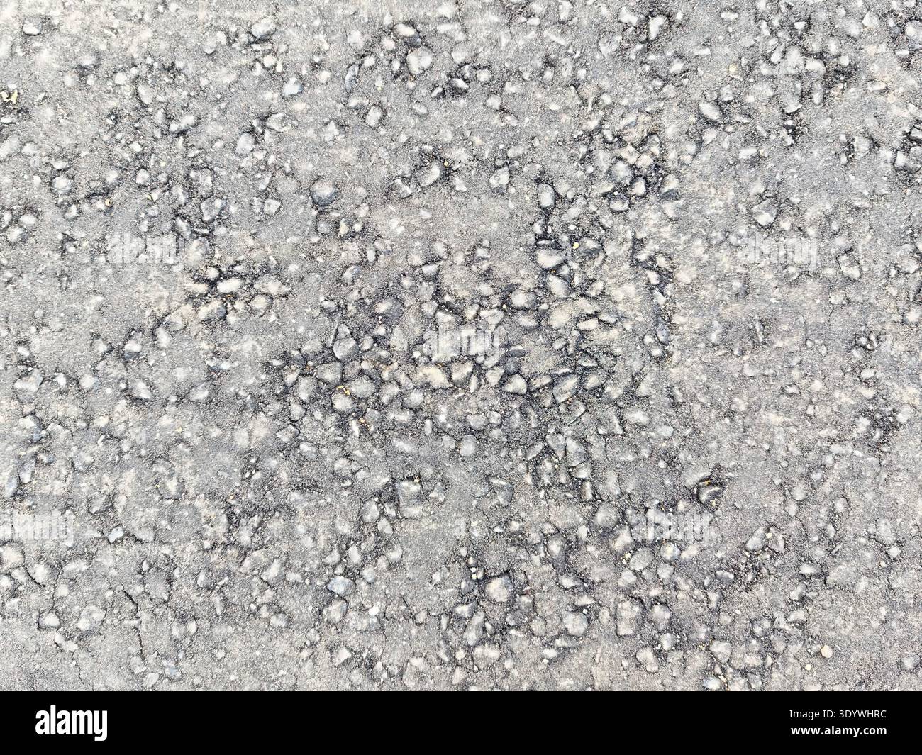 Surface features a textured grey background with small, scattered pebbles. This design can be used for creative projects that require space for text. Stock Photo