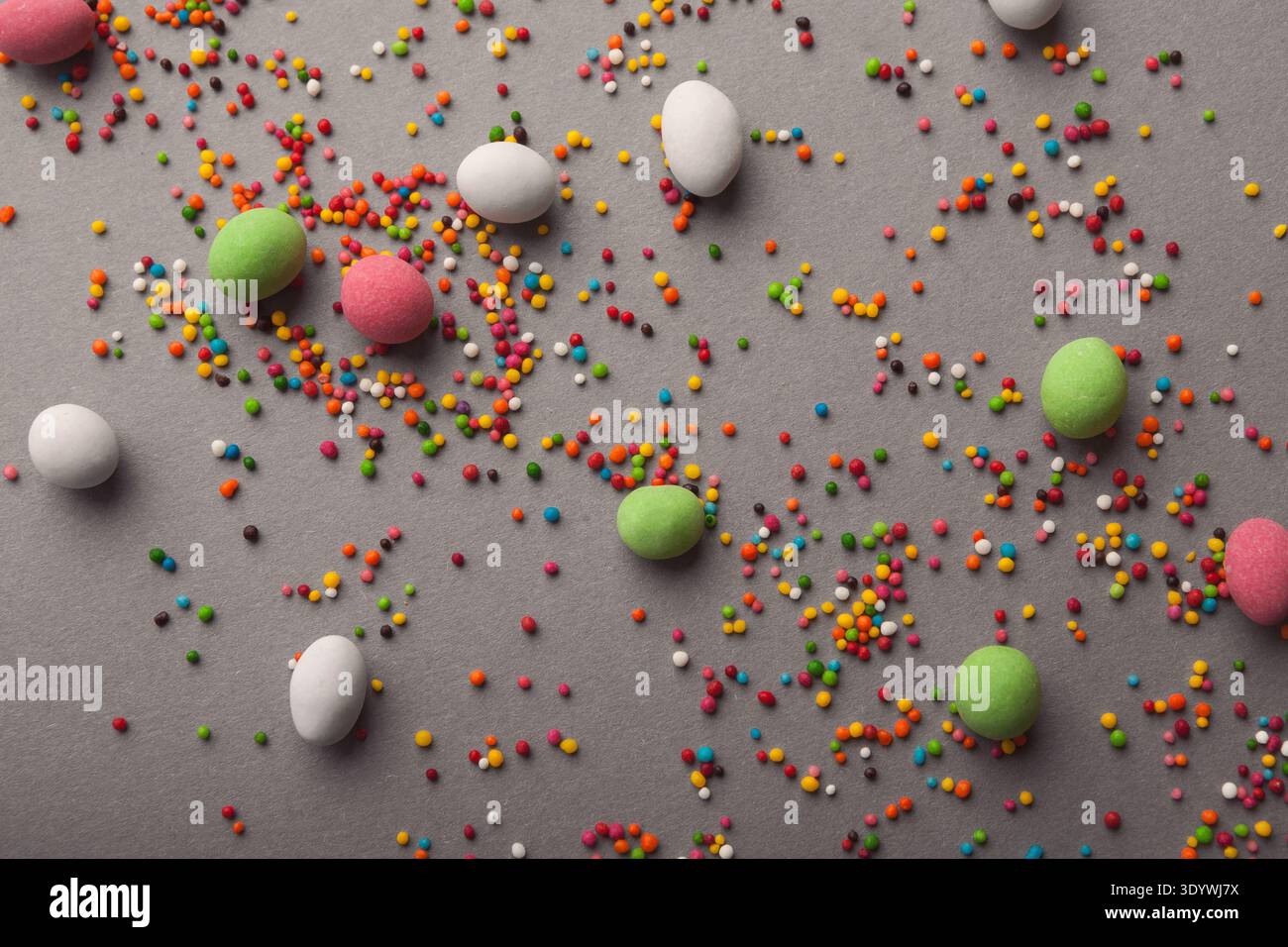 Various sweets and colorful sprinkles on gray table Stock Photo