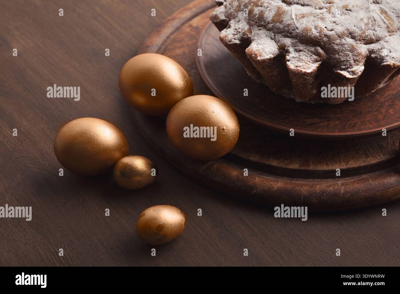 Golden eggs and easter cake on table Stock Photo