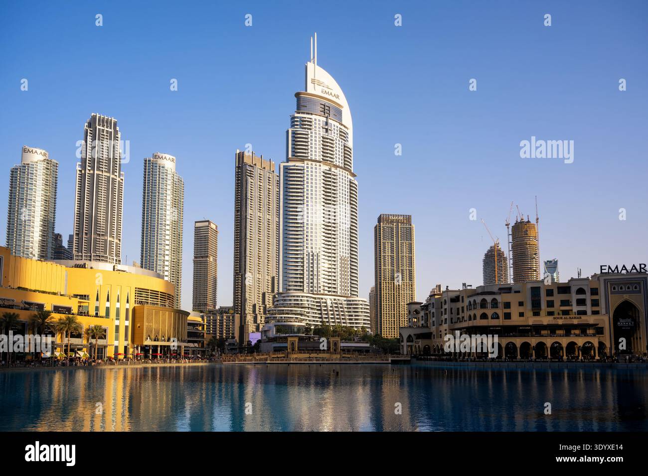 A wide exterior shot of a modern urban skyline featuring a prominent curved skyscraper and several tall residential and commercial buildings. The stru Stock Photo