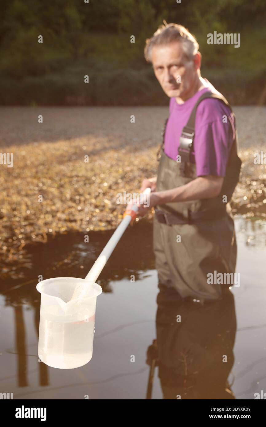 Waders Sample Water quality analyst dressed in chest wader collecting samples Stock ...