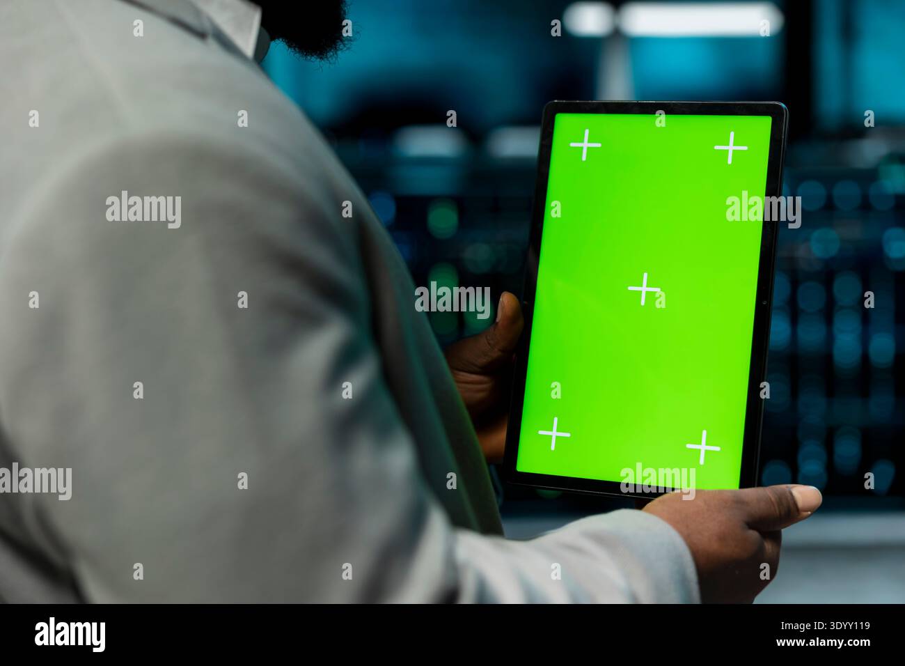 Close up of programmer in data center using isolated screen tablet to check for server performance issues. IT professional in server hub fixing errors slowing down hardware using chroma key device Stock Photo
