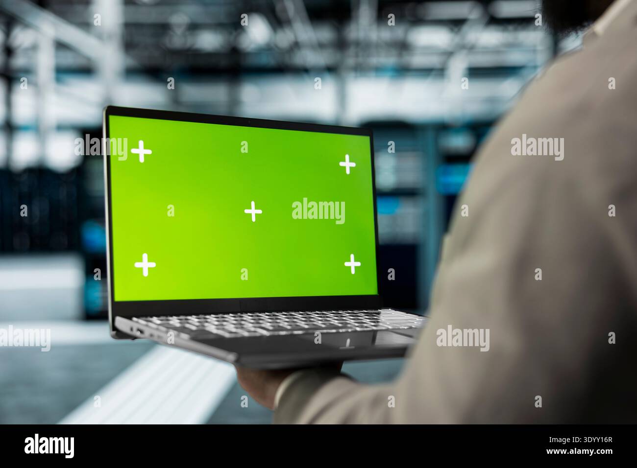 Close up of technician using green screen laptop in high tech data center to check for server performance issues. Server hub workplace employee fixes errors slowing down hardware using mockup notebook Stock Photo