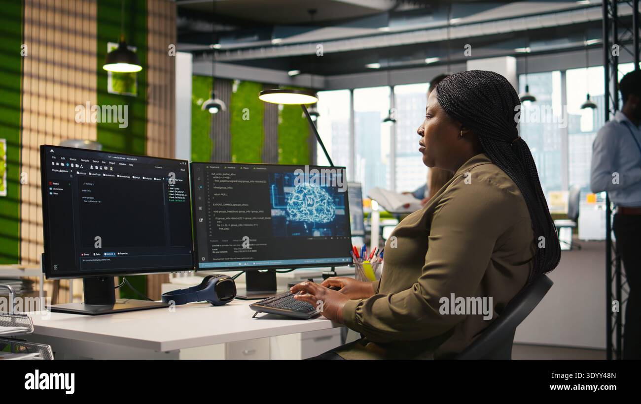 Female technician writing code on PC, developing neural networks APIs. System administrator using computer to troubleshoot software errors with artificial intelligence technology, camera A Stock Photo