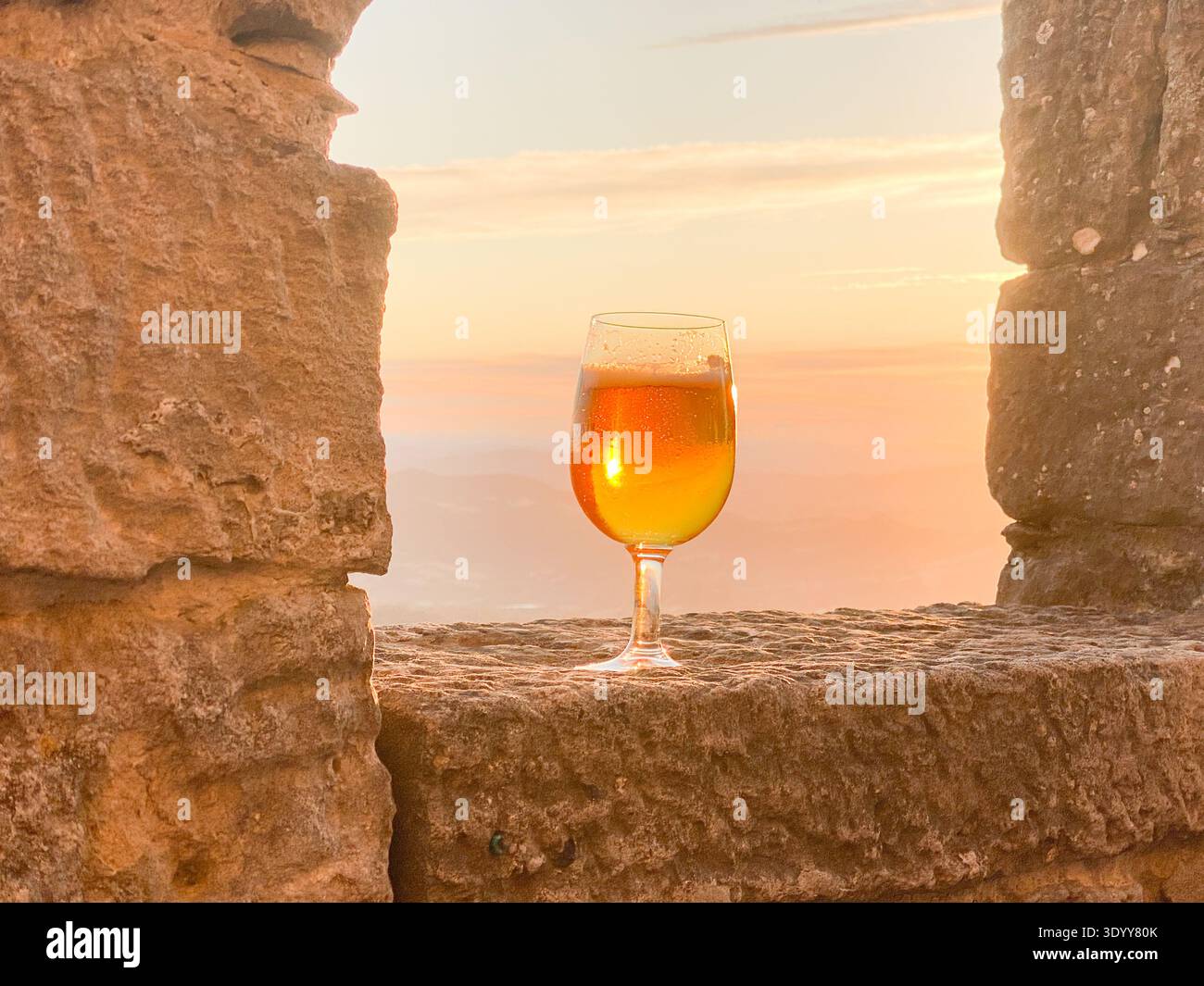Glass of Cold beer at the medieval city walls of San Marino during sunset - Smartphone Captured Stock Image
