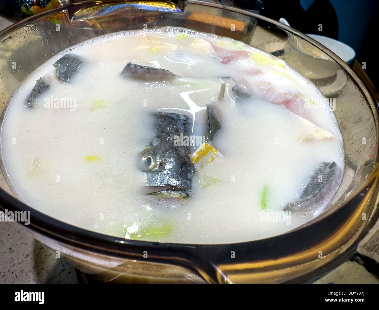 Savory, rich and very very fresh fish soup to be cooked at tableside in specialty restaurant in Shanghai, China - Smartphone Captured Stock Image