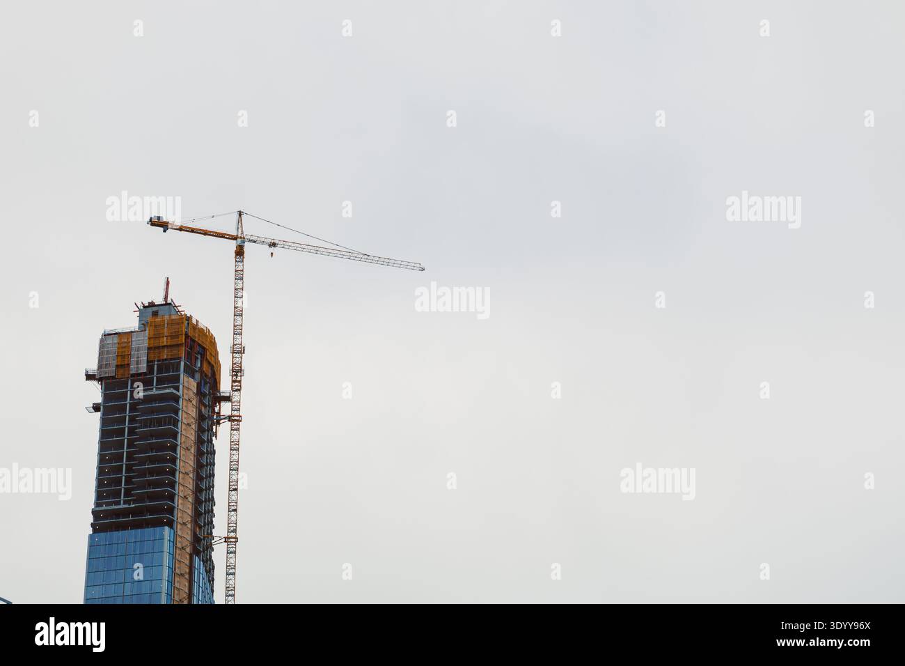 A crane is lifting building materials at a construction site in a city ...