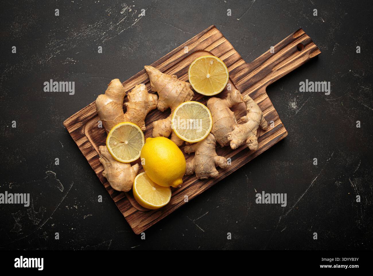 Ginger root with lemon on a wooden board Stock Photo