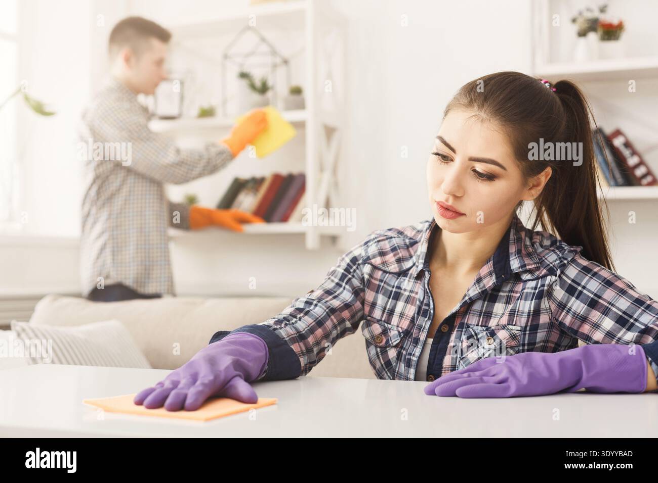 Young couple wiping dust together Stock Photo