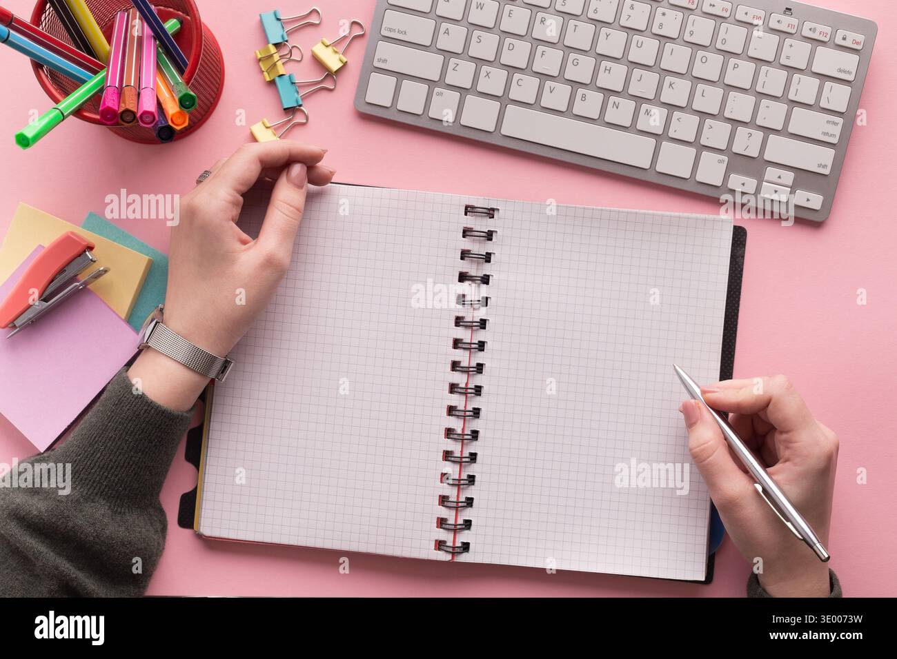 Woman's hands writing in spiral notepad Stock Photo