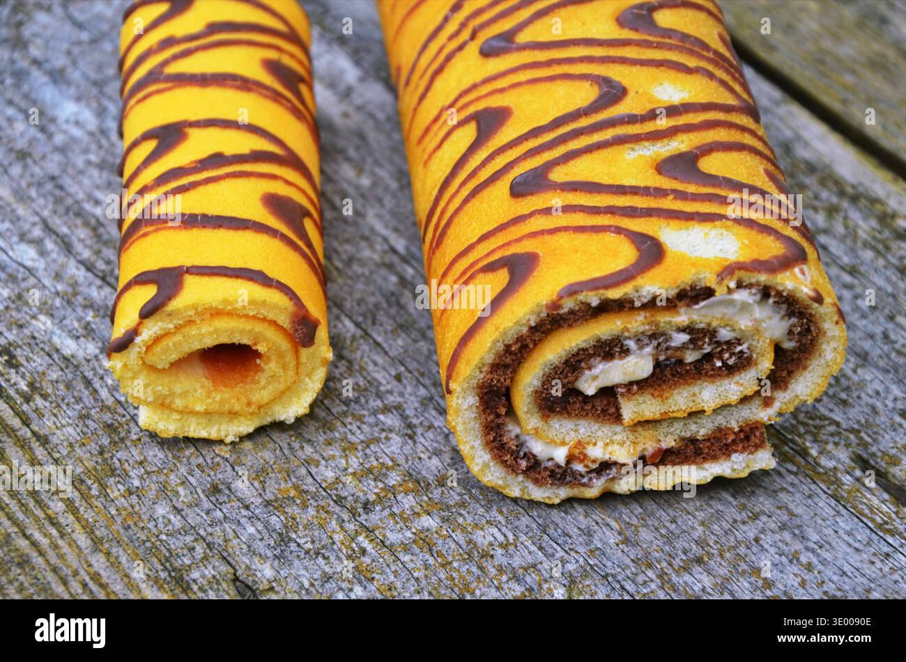 Attractive roll in chocolate and flowers. Stock Photo