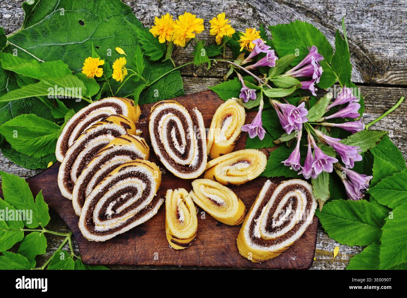 Attractive roll in chocolate and flowers. Stock Photo