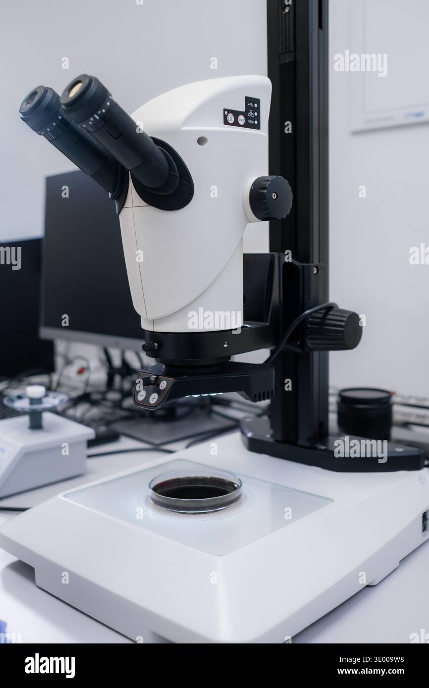 Microscope Over Datatable Advanced digital microscope positioned over a glass slide containing ...
