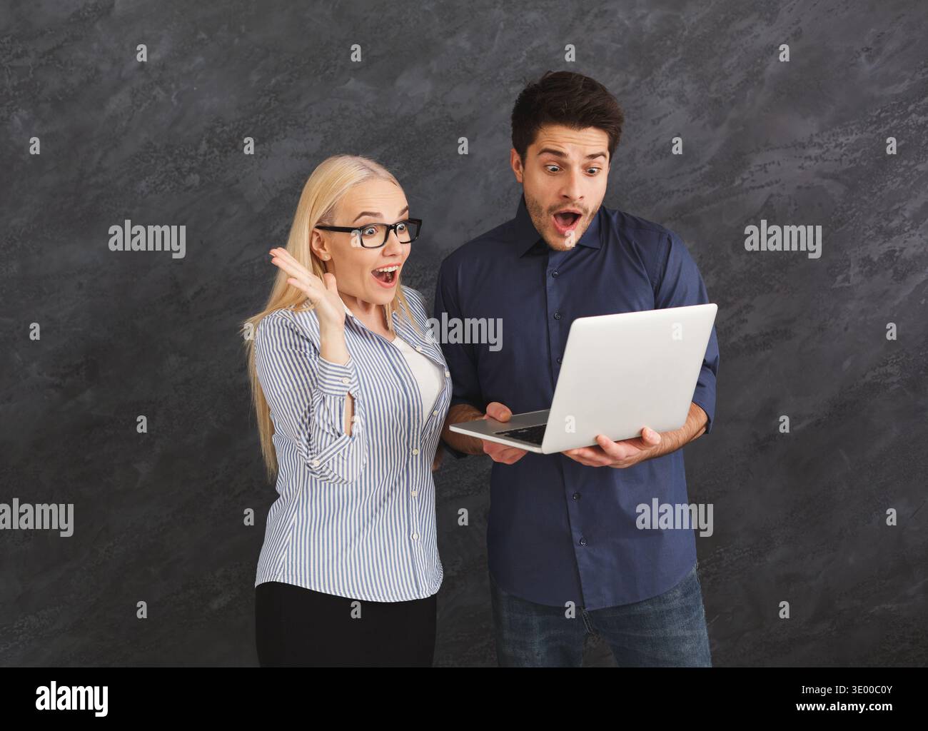 Shocked couple using laptop at studio Stock Photo