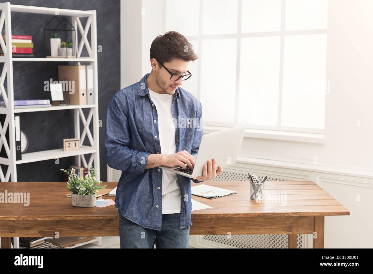 Young concentrated businessman using laptop Stock Photo
