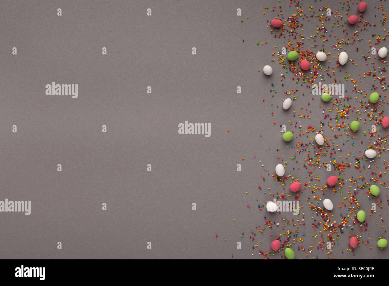 Various sweets and colorful sprinkles on gray table Stock Photo