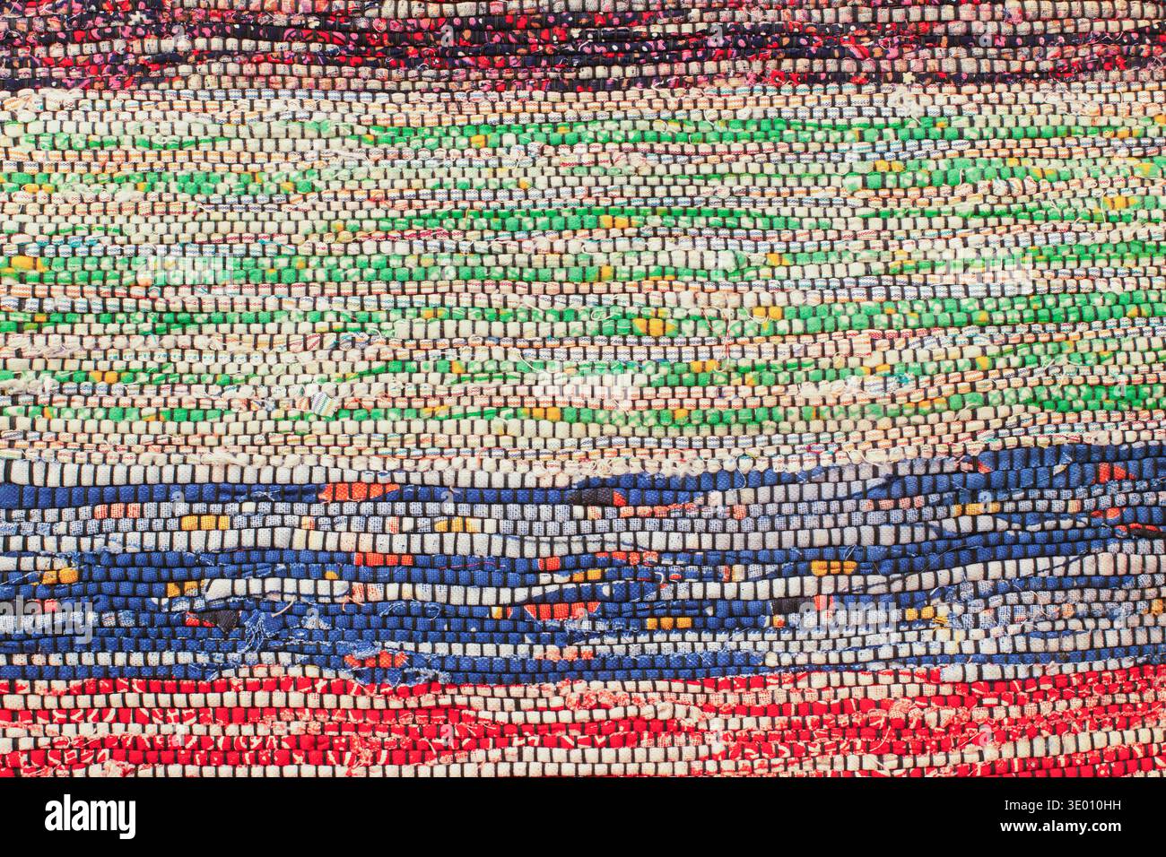 Bright multicolored hand-woven rag rug texture with blue, green and red stripes Stock Photo