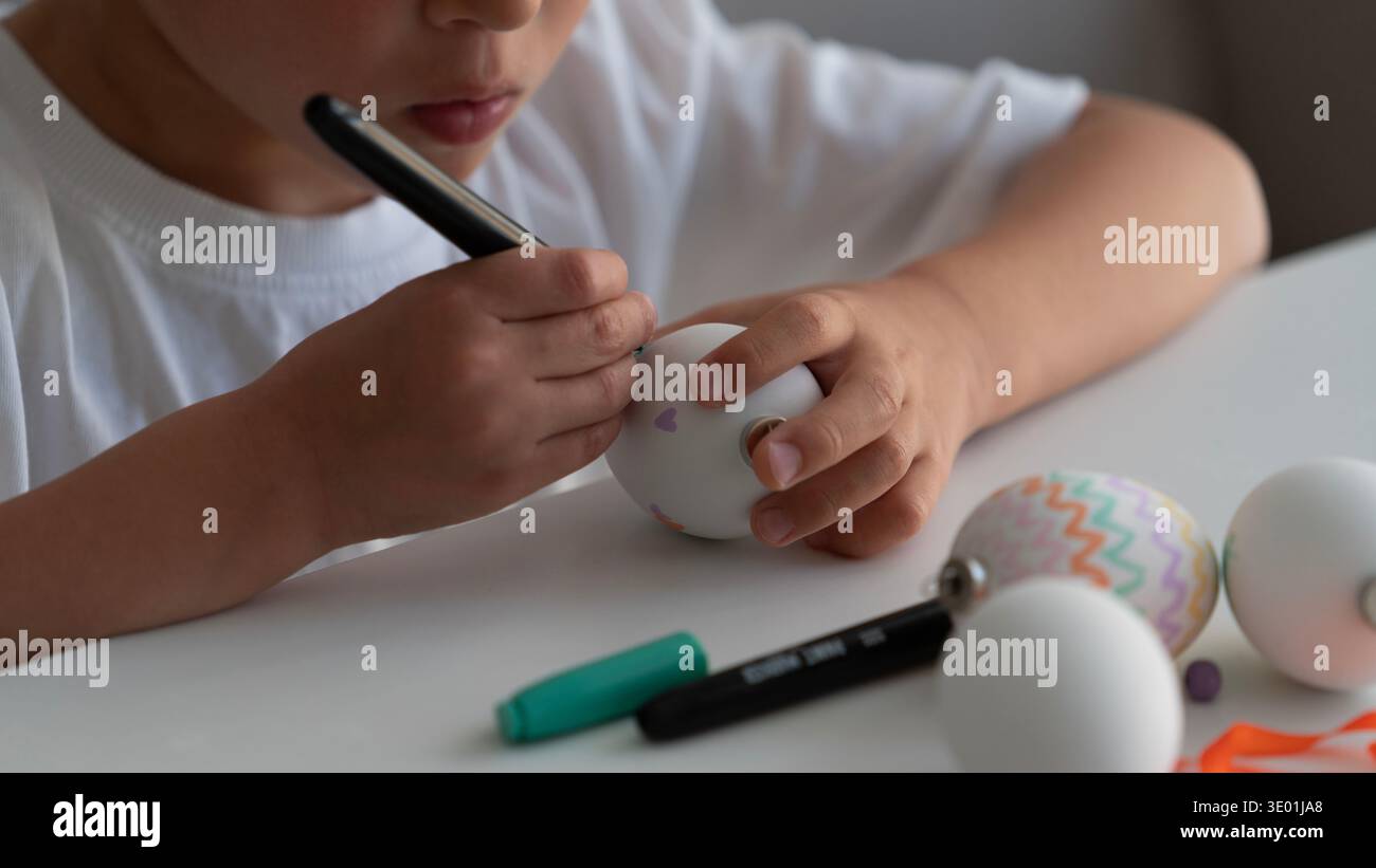 Child Decorating Easter Egg with Marker Close Up Stock Photo