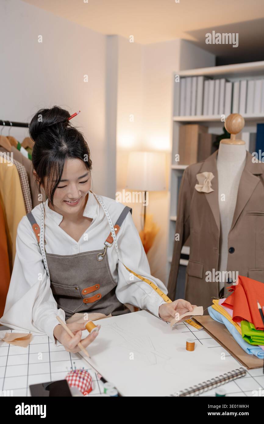 Fashion designer working in clothing studio while planning garment patterns and tailoring ideas, developing creative apparel concepts for a new fashio Stock Photo