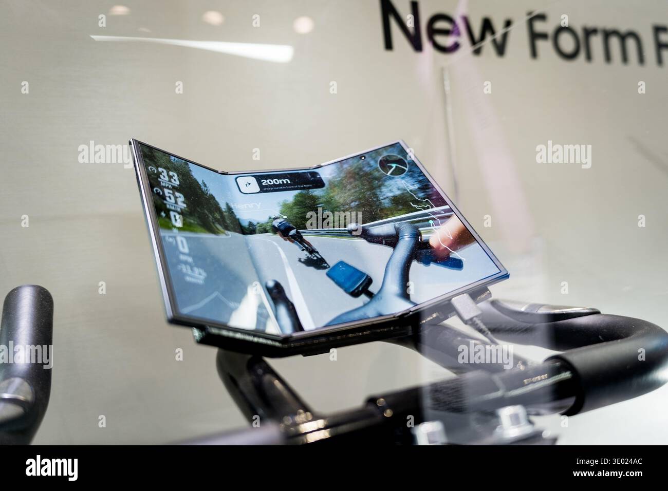 a foldable phone with foldable display on a ebike for training, concept of new smartphones and mobile technology Stock Photo