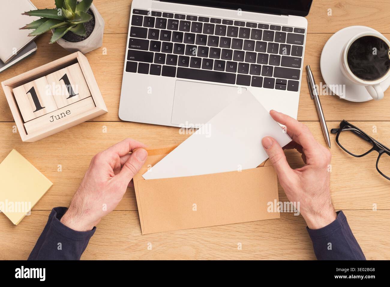 Man open envelope at workplace while working Stock Photo