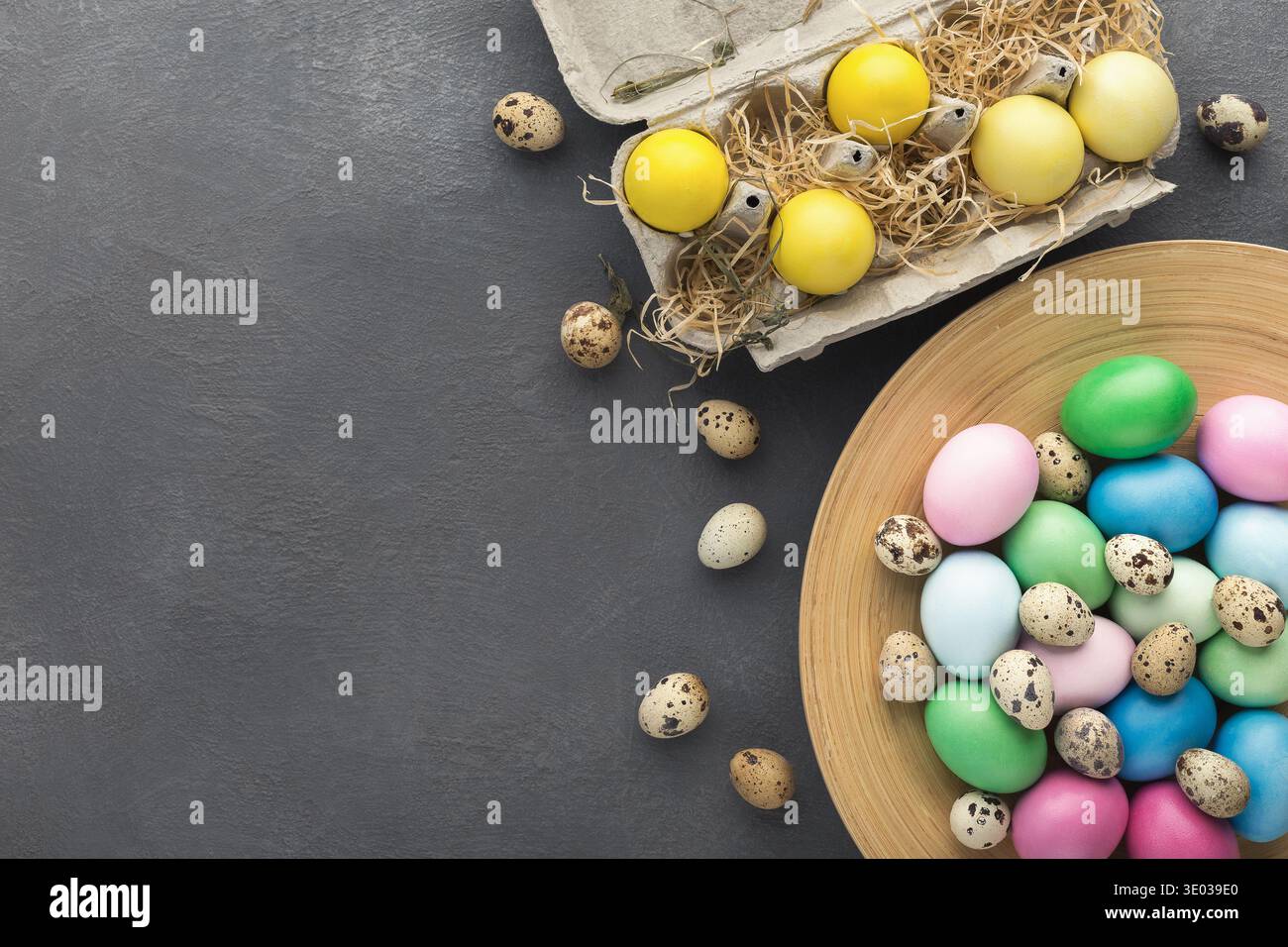 Colored Easter and quail eggs set on black table Stock Photo
