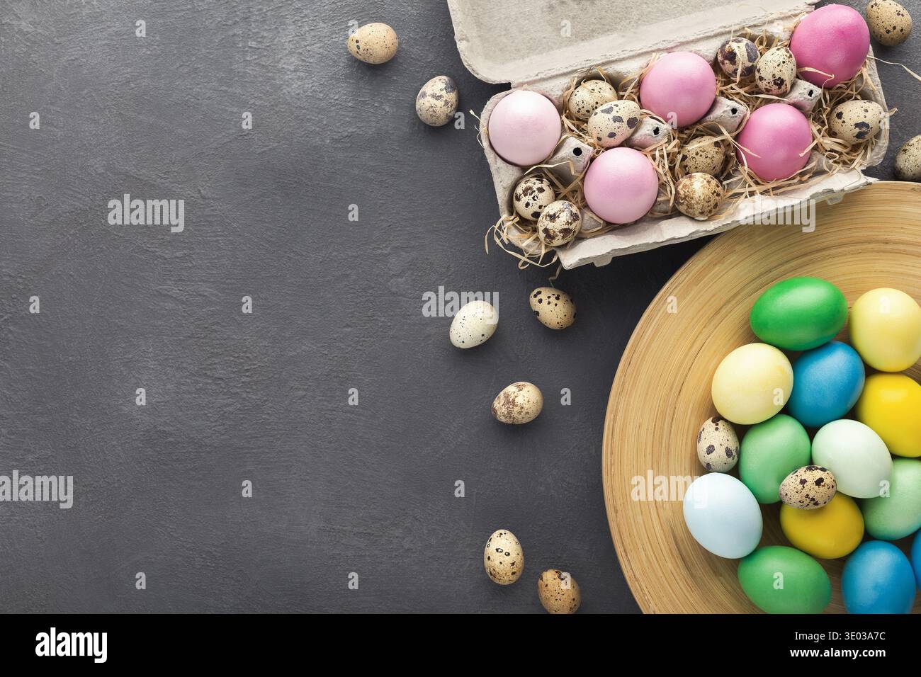 Colored Easter and quail eggs set on black table Stock Photo