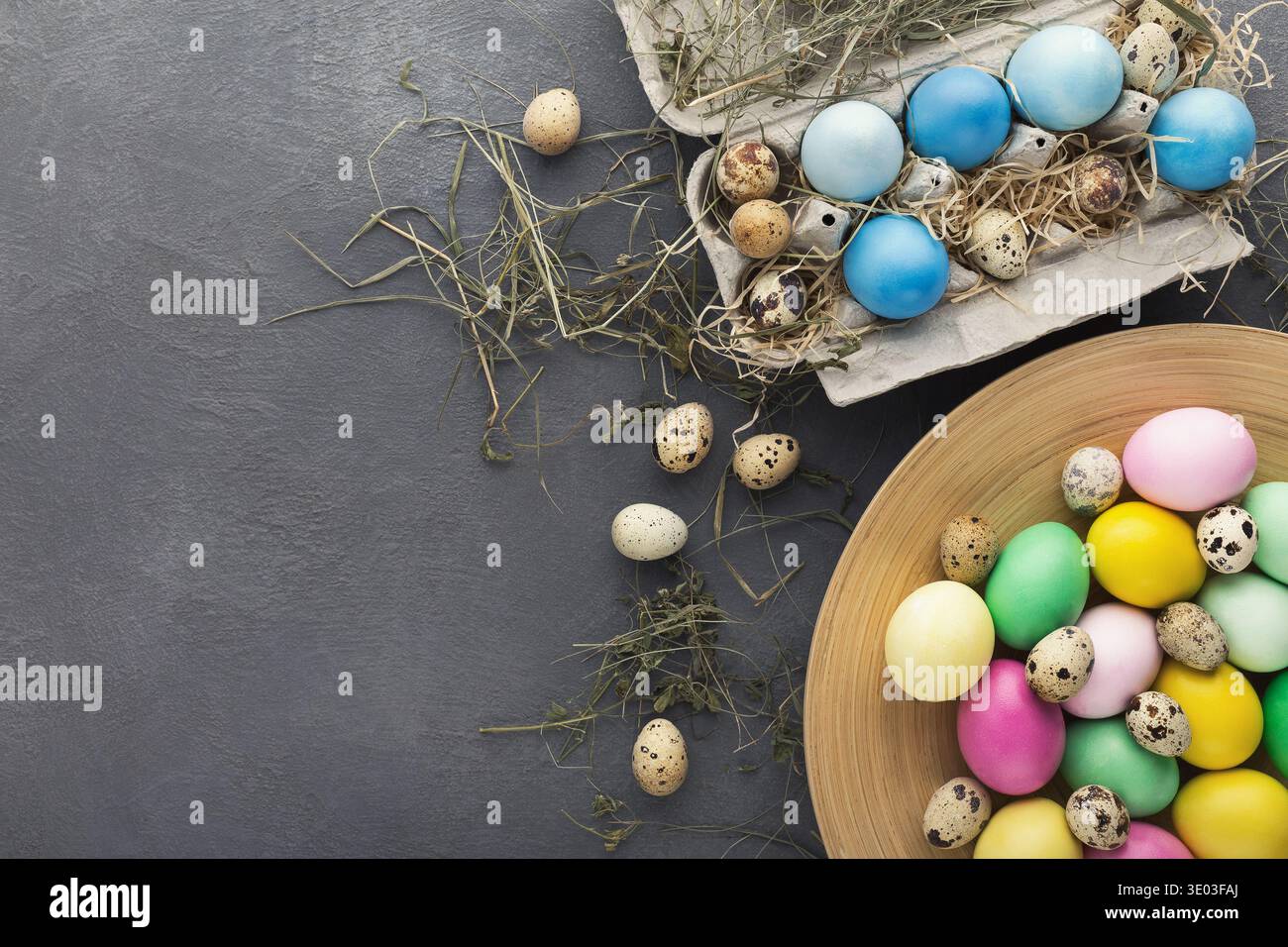 Colored Easter and quail eggs set on black table Stock Photo