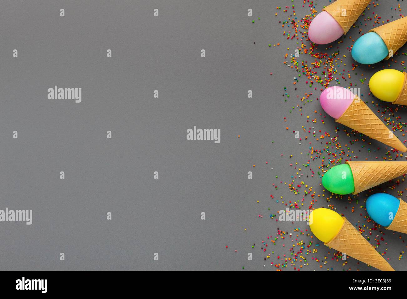 Colorful easter eggs in waffle cones on gray background Stock Photo
