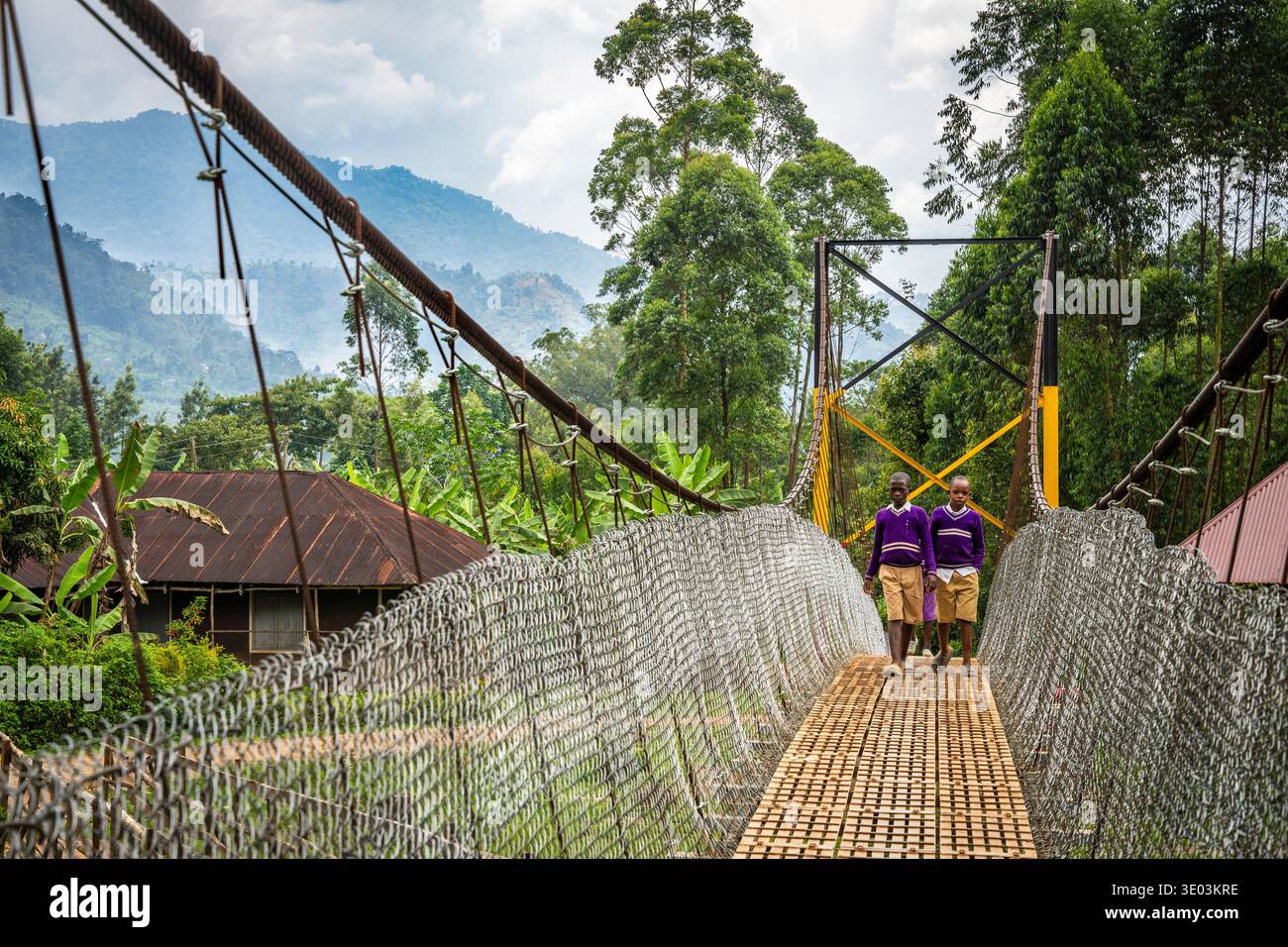 Schoolchildren walk on a rope bridge ove the Manafura river near Bulucheke, Mt Elgon, eastern Uganda Stock Photo