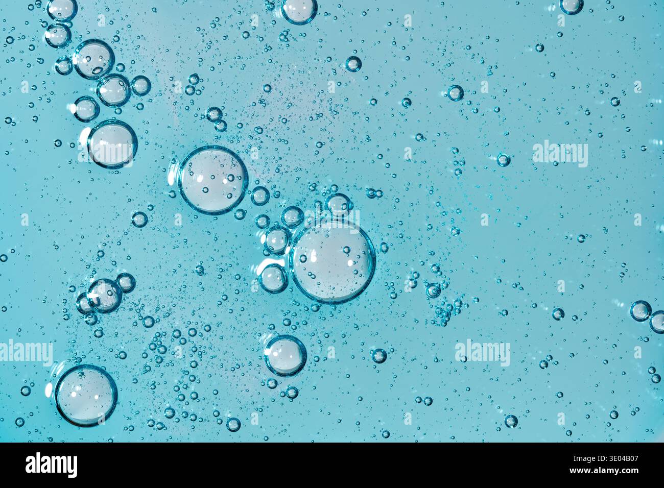 Abstract close-up of bubbles floating on a blue liquid surface, creating intricate patterns and textures. Ideal for scientific and artistic uses, show Stock Photo
