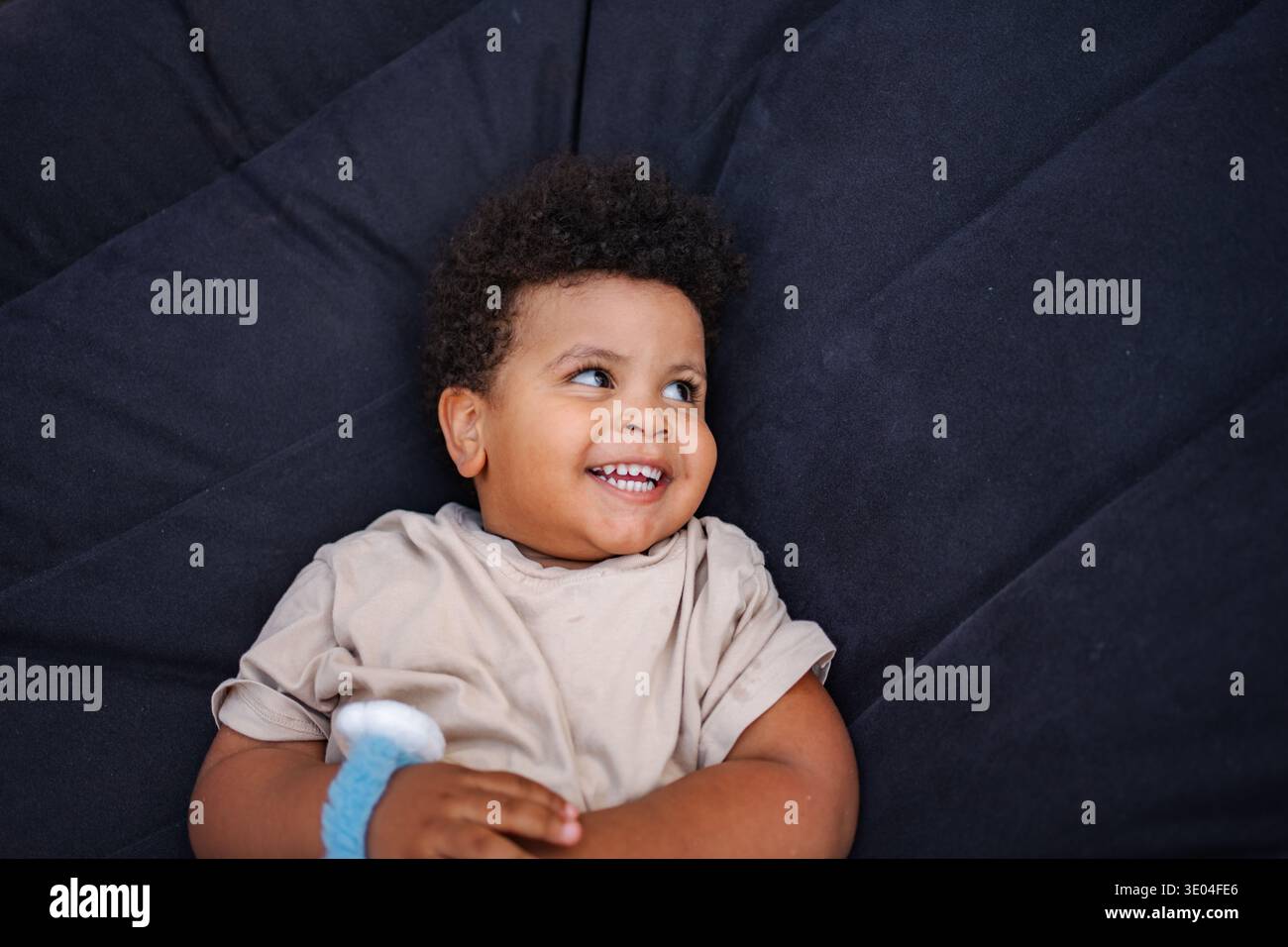 Happy toddler boy lying down smiling Stock Photo