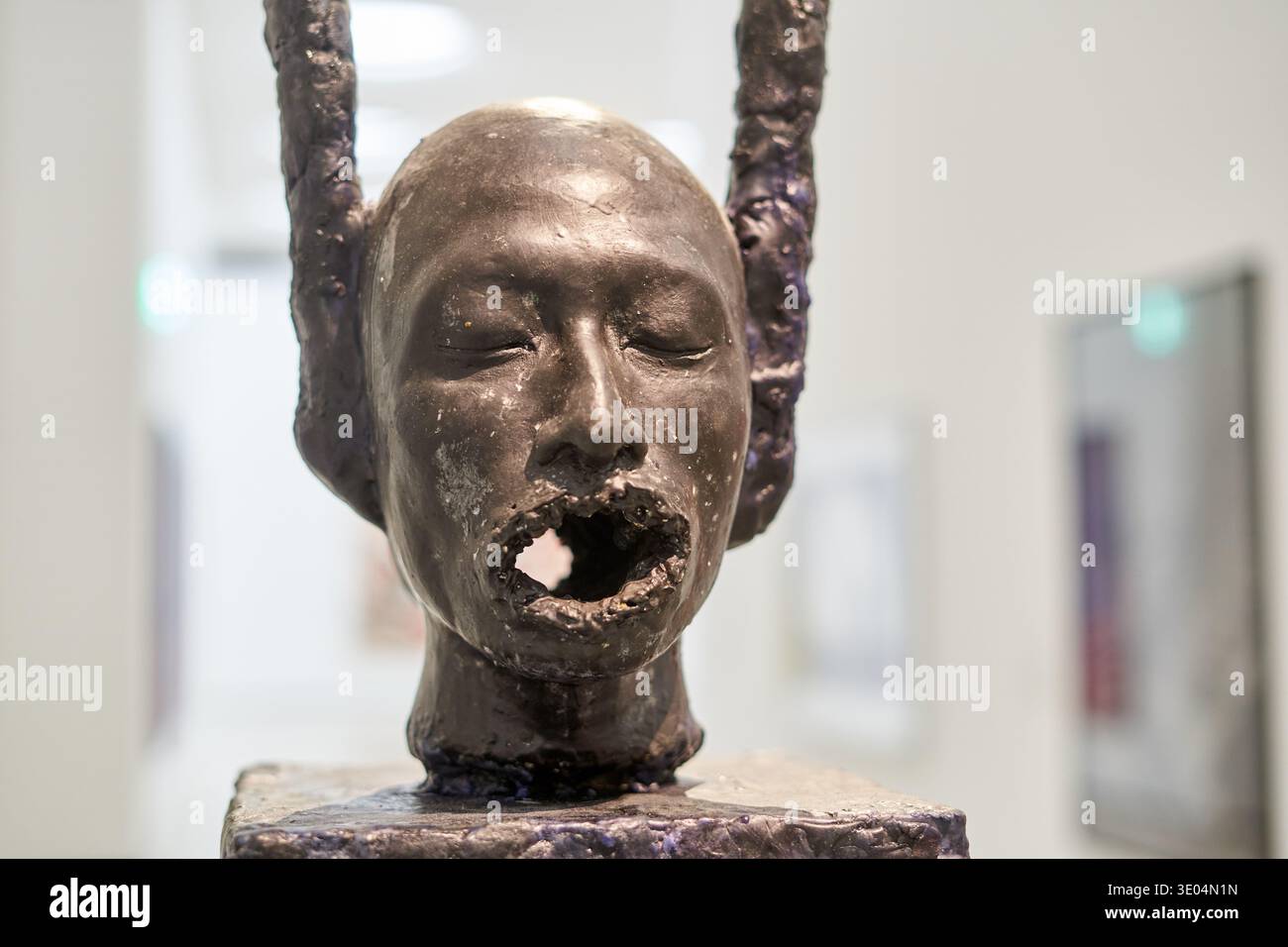 Rectangular Human Head Close-up view of a bronze sculpture depicting a human head with closed ...