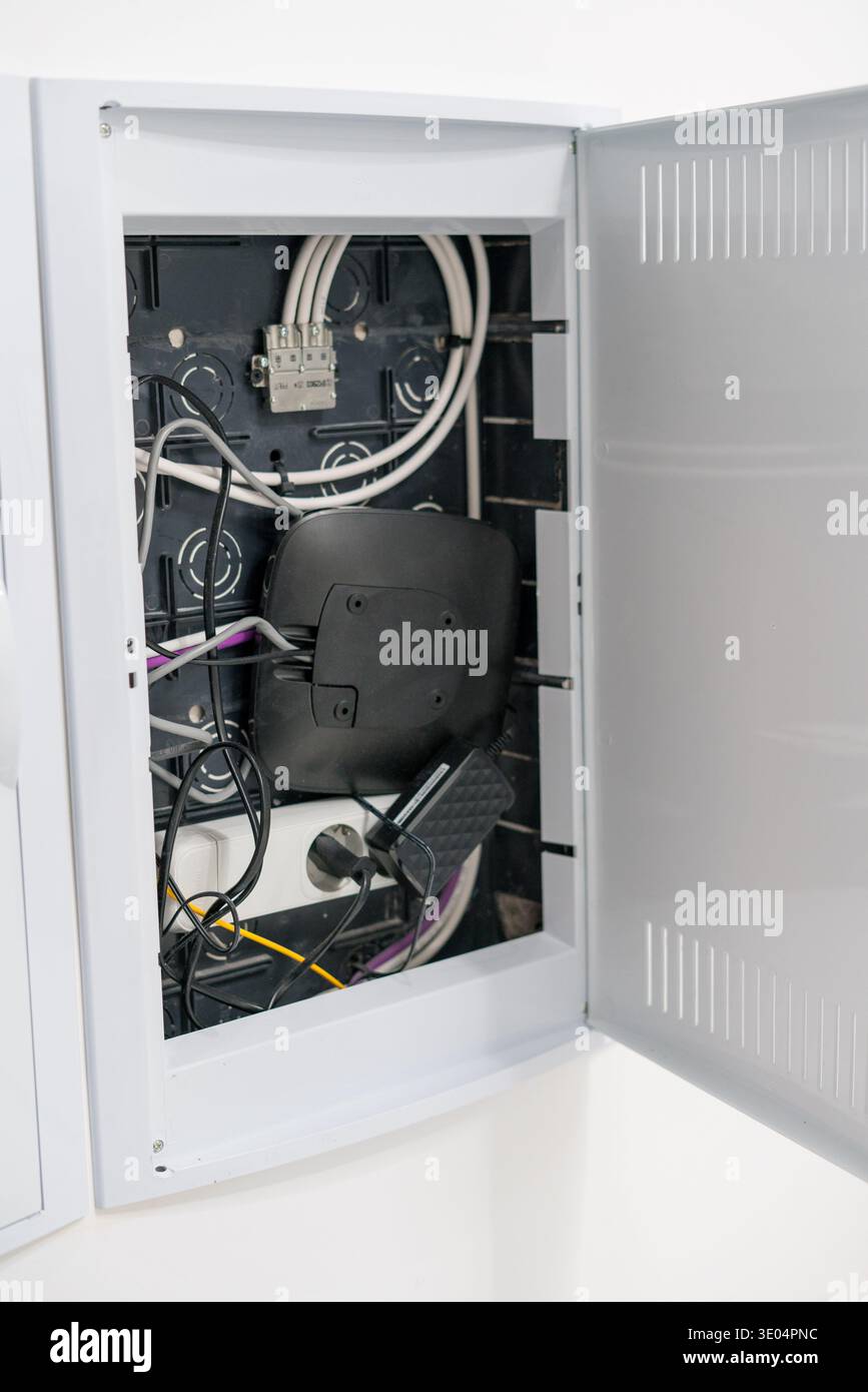 Open electrical distribution box with cables and network equipment Stock Photo