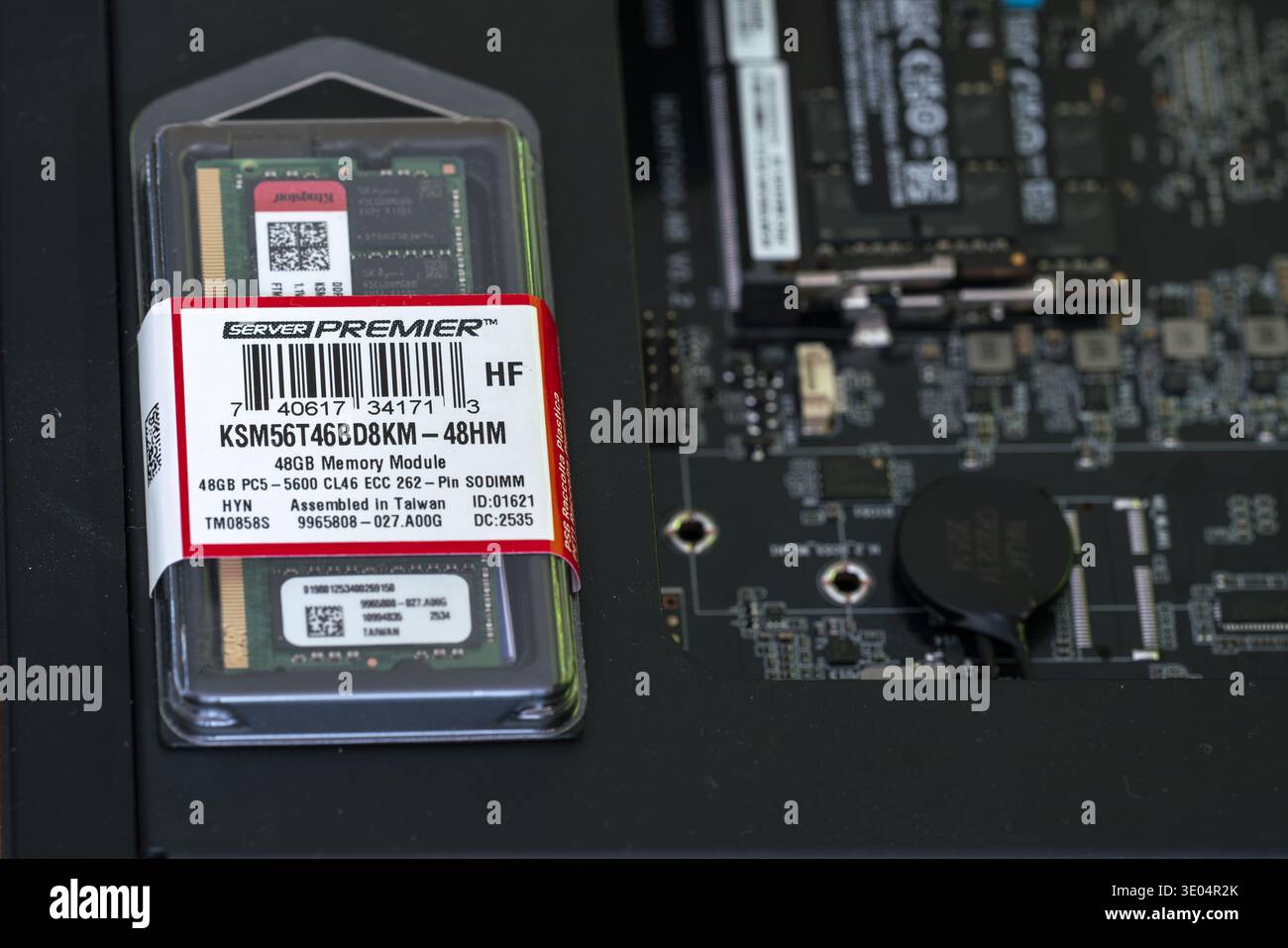 Close-up of a 48GB DDR5 ECC SODIMM memory module in protective packaging, labeled Server Premier, displayed next to a server motherboard. Stock Photo