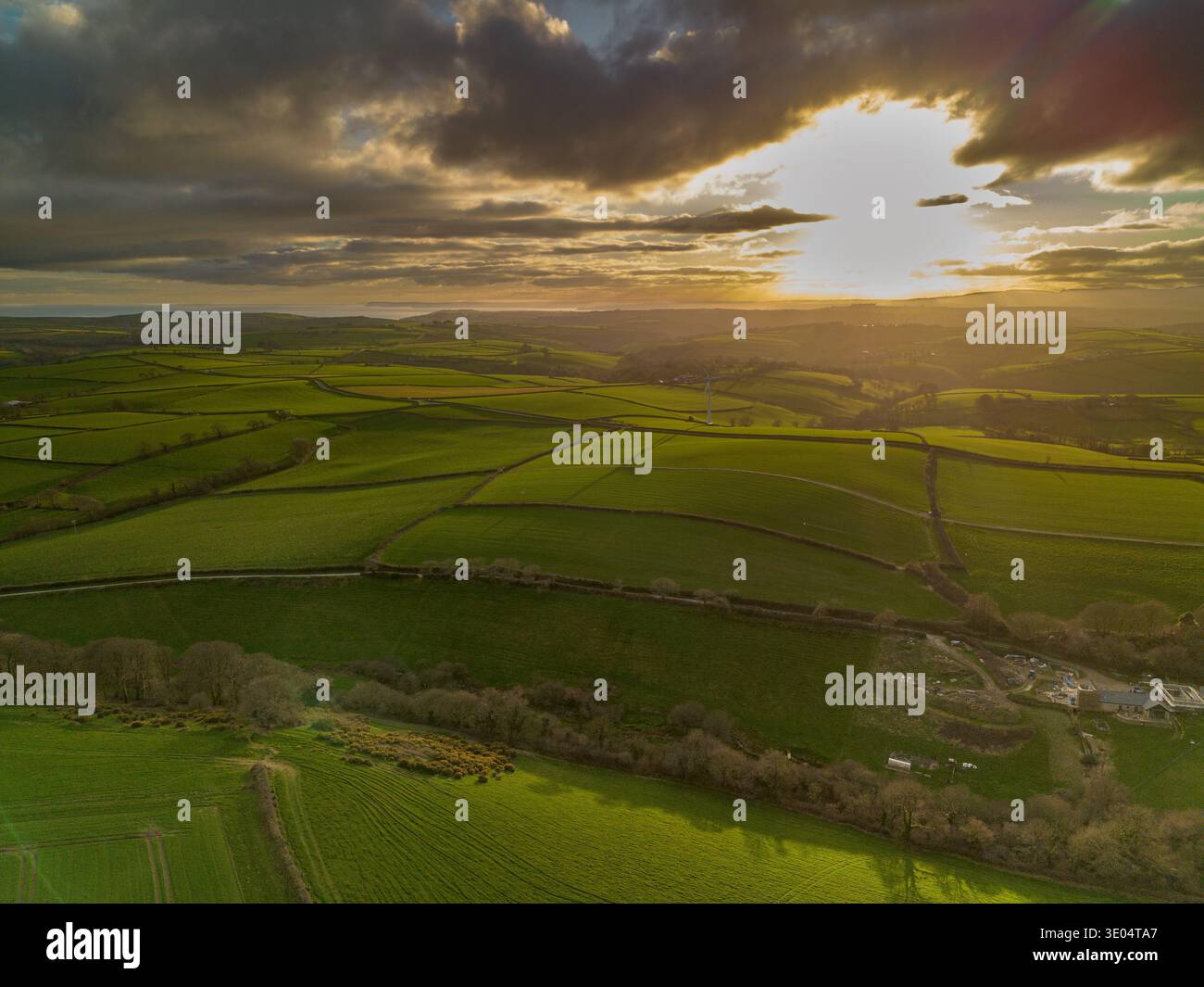 Aerial drone photograph of sunset light over patchwork farmland fields and rolling countryside landscape near Looe in Cornwall, England. Stock Photo