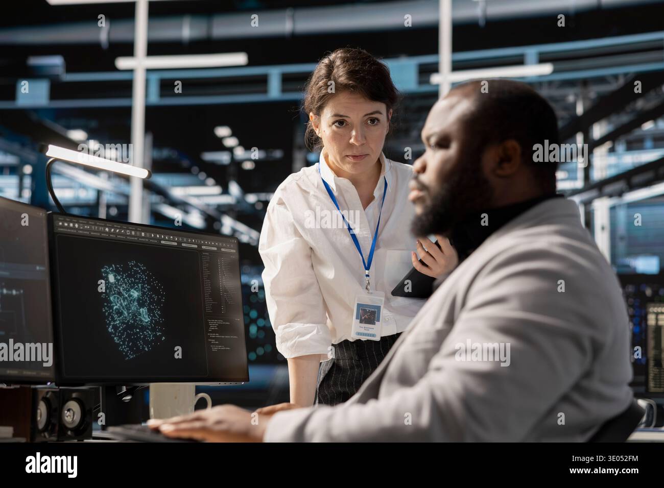 Manager supervising engineer in data center managing server virtualization, running scripts. Team leader overseeing work done by employee using programming language in server farm Stock Photo