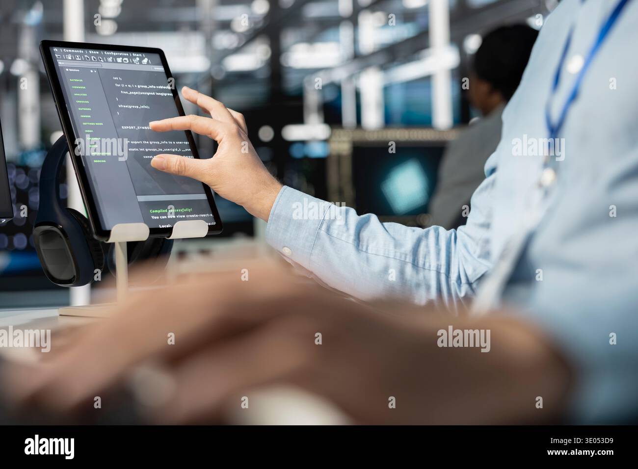 Close up of software developer using tablet in data center, managing server virtualization, running scripts. IT professional using programming language on touchscreen device in server farm Stock Photo