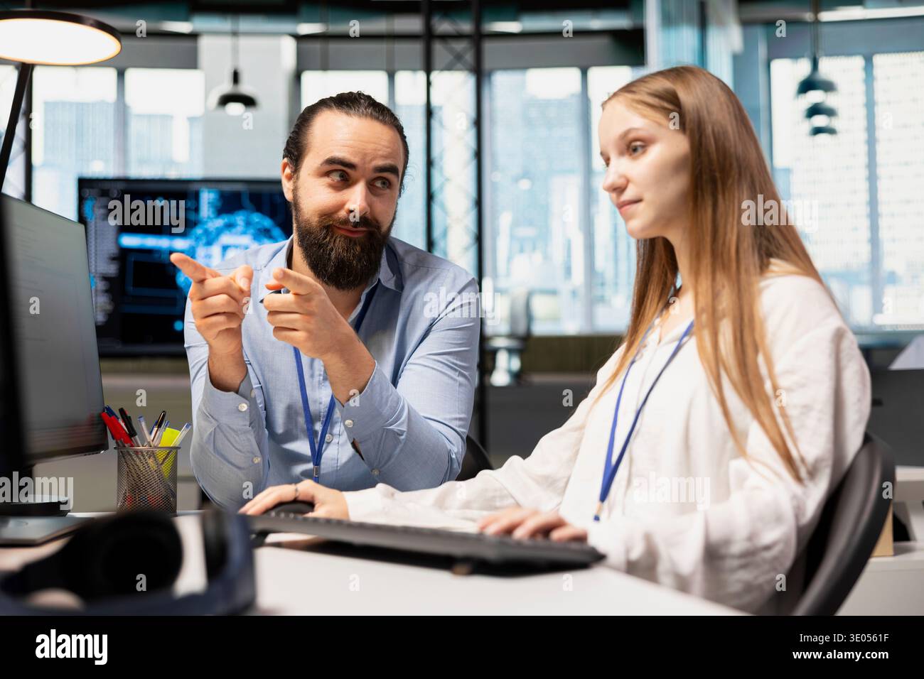 Senior programmer guiding junior developer through AI tool integration, mentoring her on using machine learning APIs. Lead developer teaching intern to use artificial intelligence Stock Photo