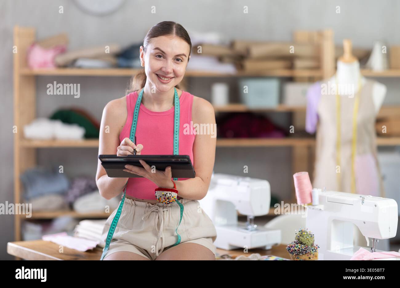 Woman dressmaker makes pattern using tablet Stock Photo