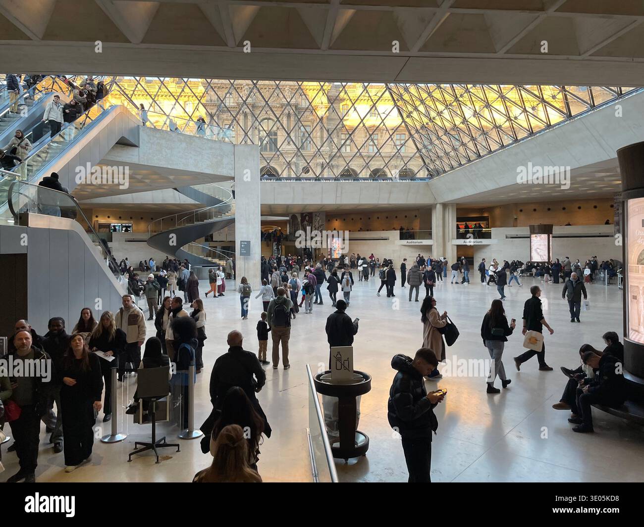 Paris, France. Visitors inside Hall Napoléon, the underground lobby of the Louvre Pyramid at the Louvre Museum. - Smartphone Captured Stock Image