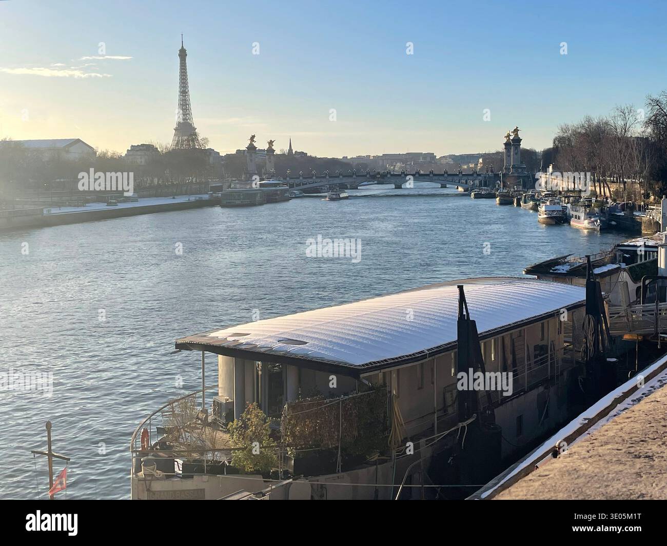 Paris, France. Boats docked on the banks of the Seine River at dusk in wintertime, with the Tour Eiffel and Pont Alexandre III seen in the back. - Smartphone Captured Stock Image