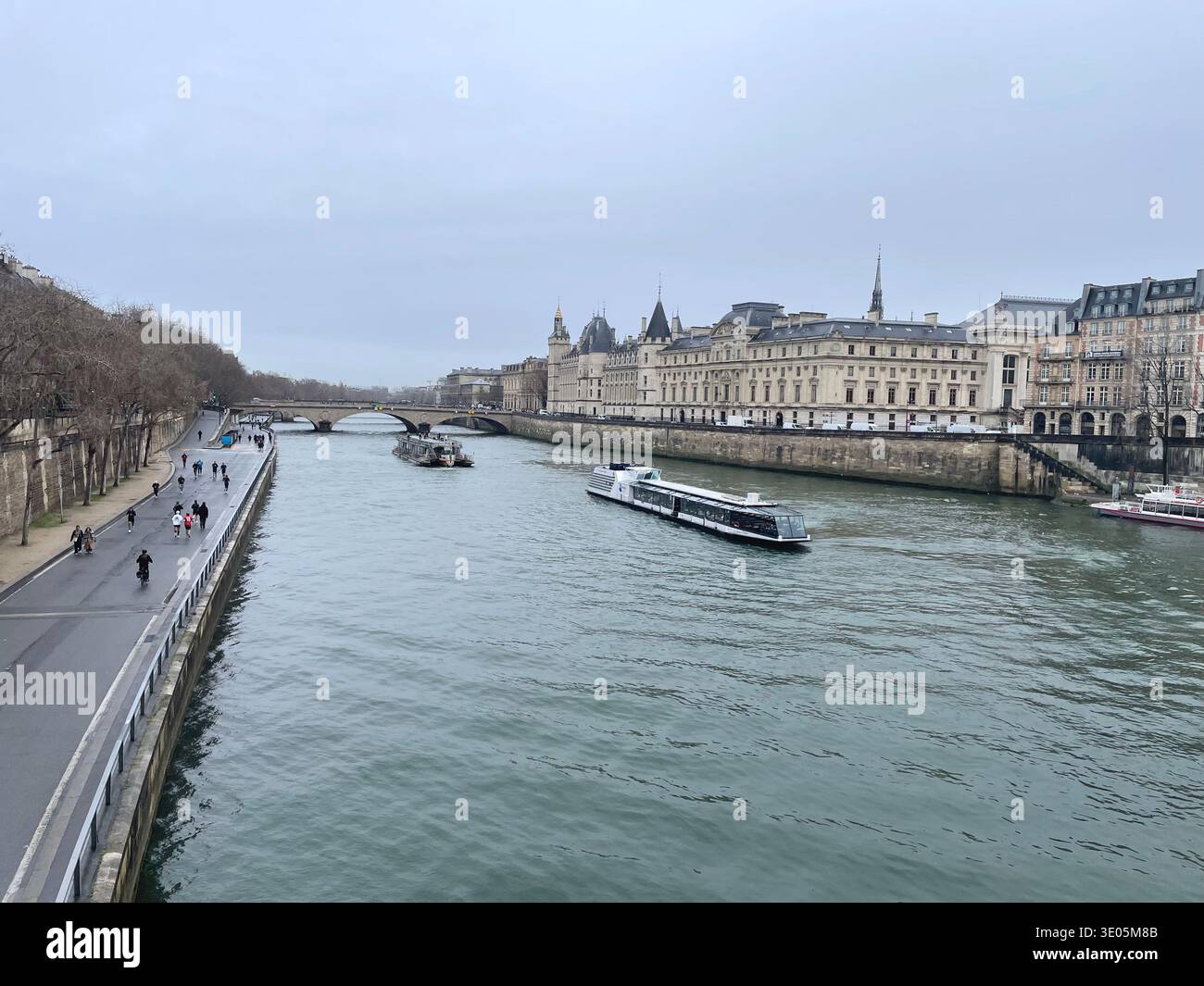 Paris, France. Tour boats on the Seine River. Ile de La City and La Conciergerie on the right. - Smartphone Captured Stock Image