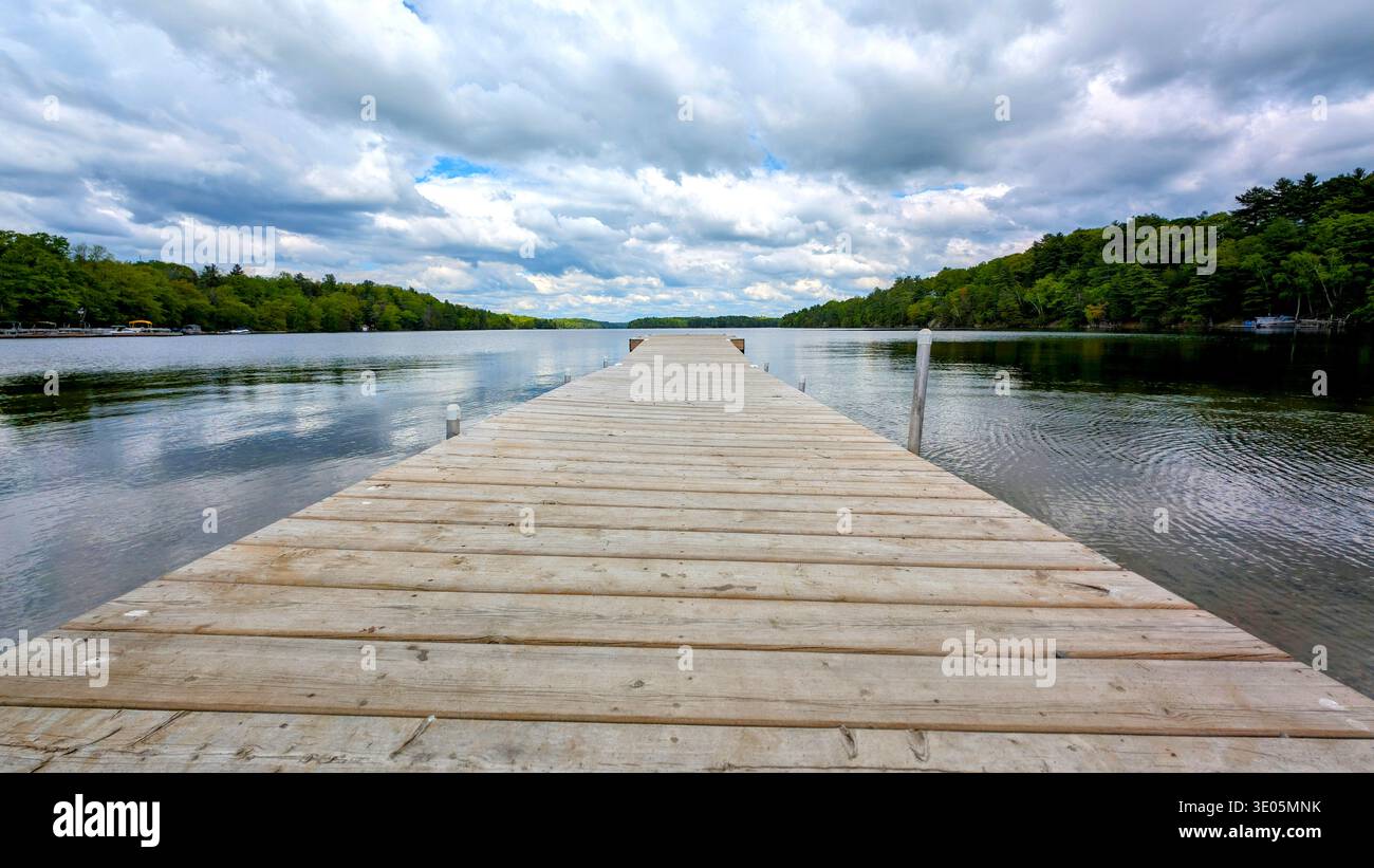 Looking Down The Wooden Dock Over The Calm Water Of A Small Lake - Smartphone Captured Stock Image