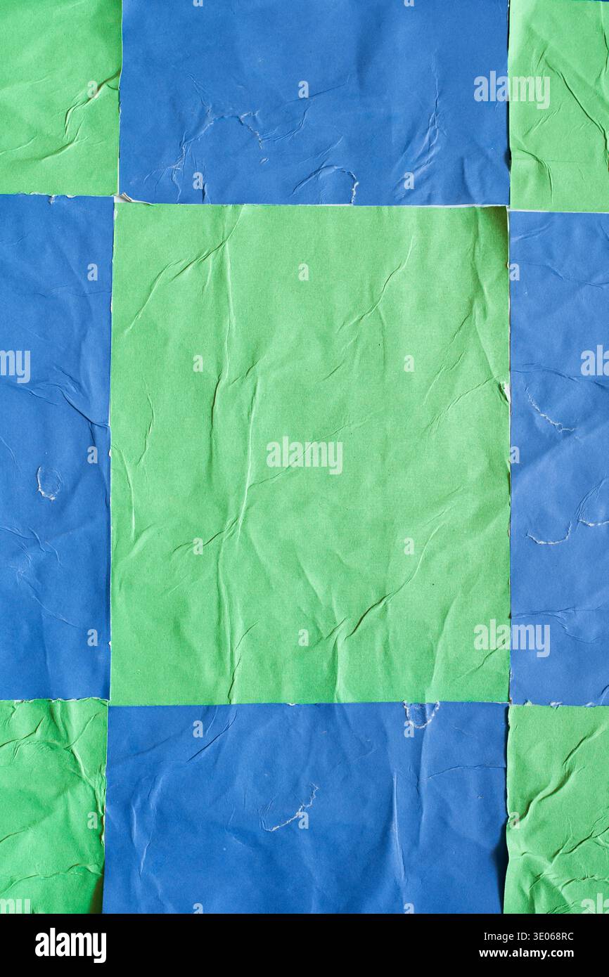 Checkered Blue and Green Vertical Posters with Wheatpaste Texture on a Wall Stock Photo